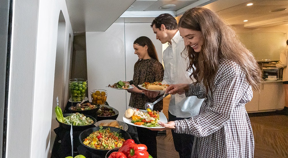 Guests serving themselves from a buffet spread on a Sydney Harbour lunch cruise