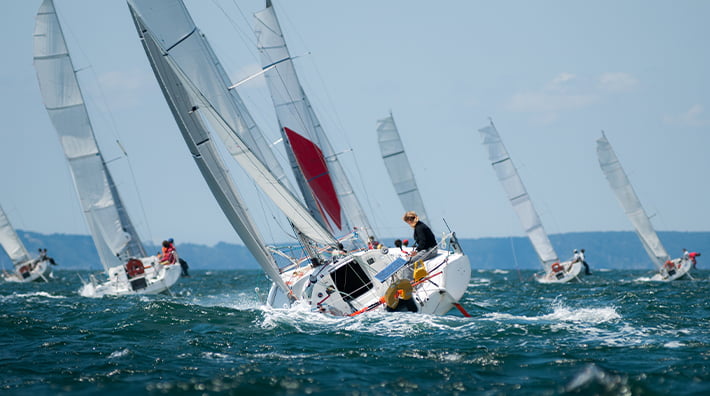 Witness the yachts compete fiercely on the azure waters during the renowned Sydney to Hobart Yacht Race.